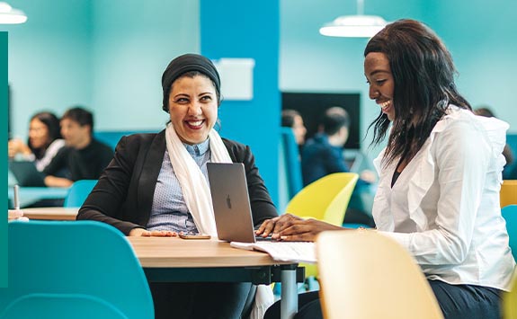 Two NUBS postgraduate researchers working at a laptop